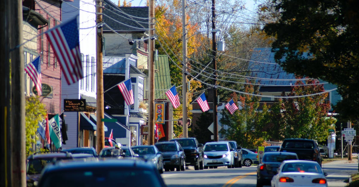 Does US preclearance in Toronto have a dedicated lane for diplomats? - Busy road running through suburban district houses with USA flags