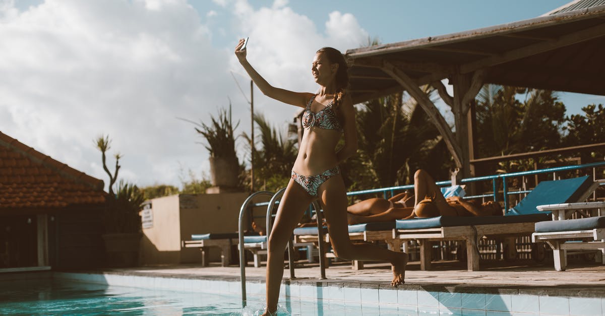 Does using International SOS amount to having travel insurance? - Full body cheerful slim female in swimwear taking selfie on cellphone while jumping into swimming pool in resort on sunny day Does using International SOS amount to having travel insurance? - Full body cheerful slim female in swimwear taking selfie on cellphone while jumping into swimming pool in resort on sunny day