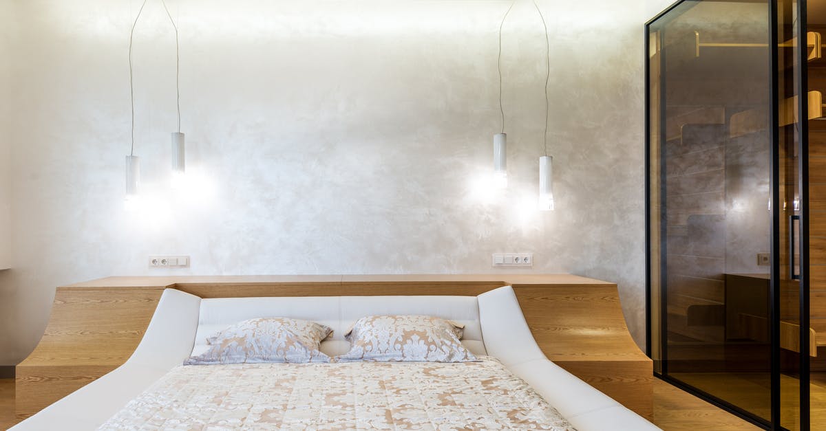 Double bed in Germany - Stylish interior design of spacious bedroom lighted with set of lamps furnished with bed and wardrobe closet with glass doors Double bed in Germany - Stylish interior design of spacious bedroom lighted with set of lamps furnished with bed and wardrobe closet with glass doors