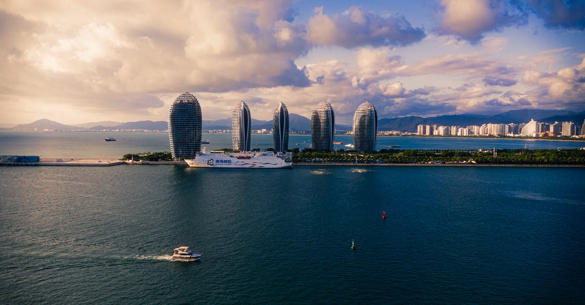 Double entry visa to China when visiting on a cruise ship - Modern cruise ships and boats floating on calm sea against cloudy sky near futuristic skyscrapers located on Phoenix Island in China Double entry visa to China when visiting on a cruise ship - Modern cruise ships and boats floating on calm sea against cloudy sky near futuristic skyscrapers located on Phoenix Island in China