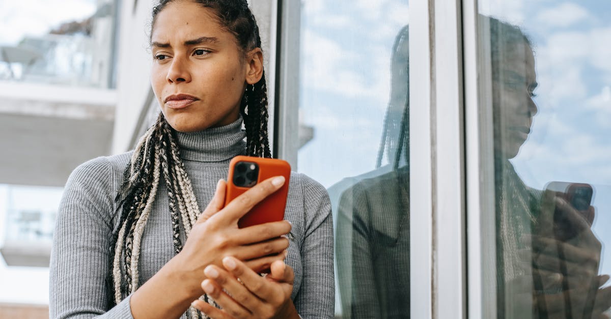 Doubt regarding a question DS160 application (countries you have visited) - Low angle of concerned ethnic female with smartphone in stressful situation near glass wall Doubt regarding a question DS160 application (countries you have visited) - Low angle of concerned ethnic female with smartphone in stressful situation near glass wall