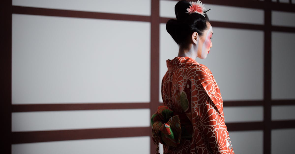 Dressing up as a Geisha/Maiko in Japan - Girl in Red Floral Kimono Standing Near White Wall Dressing up as a Geisha/Maiko in Japan - Girl in Red Floral Kimono Standing Near White Wall
