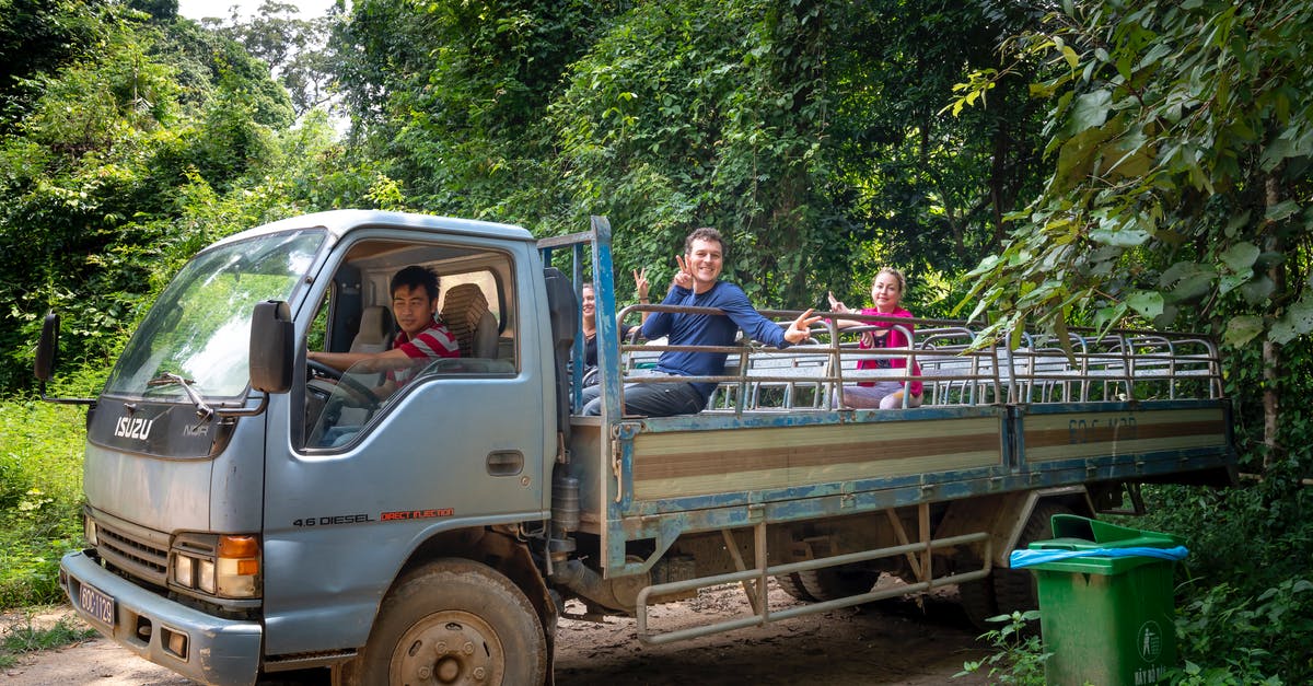 driving abroad with own car and local law on modifications, differences between what's is legal on a car and what isn't - Cheerful travelers riding in truck with Asian driver during excursion in tropical green forest driving abroad with own car and local law on modifications, differences between what's is legal on a car and what isn't - Cheerful travelers riding in truck with Asian driver during excursion in tropical green forest