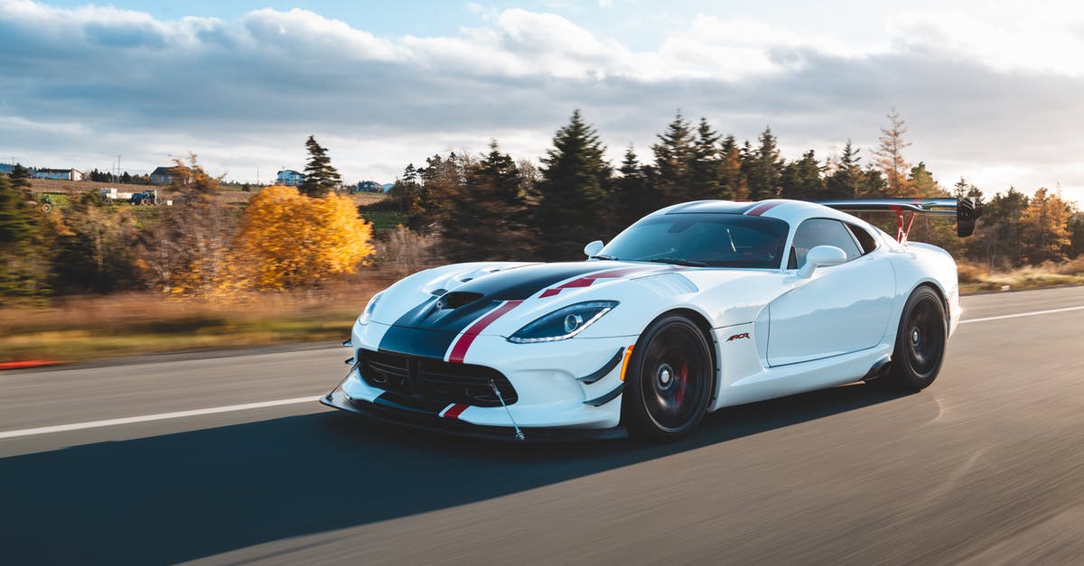 Driving non-GB registered car inside Low Emission Zone - New sport car driving on road in countryside in autumn Driving non-GB registered car inside Low Emission Zone - New sport car driving on road in countryside in autumn