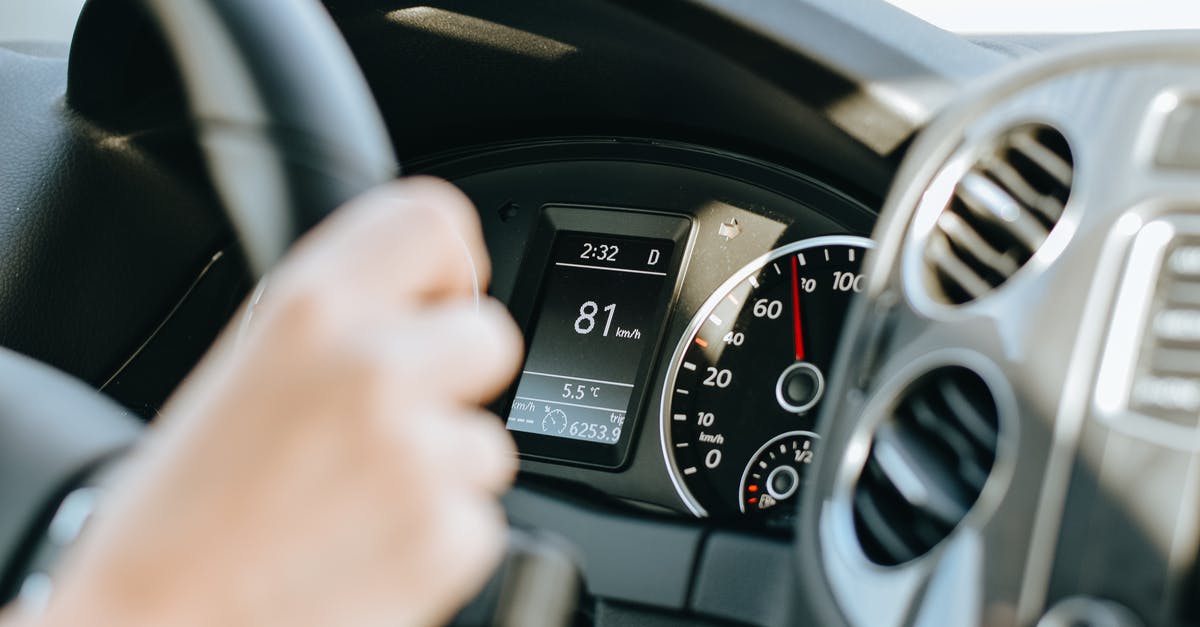 Driving time around Iceland - Crop anonymous person holding black steering wheel and driving car in sunny day Driving time around Iceland - Crop anonymous person holding black steering wheel and driving car in sunny day