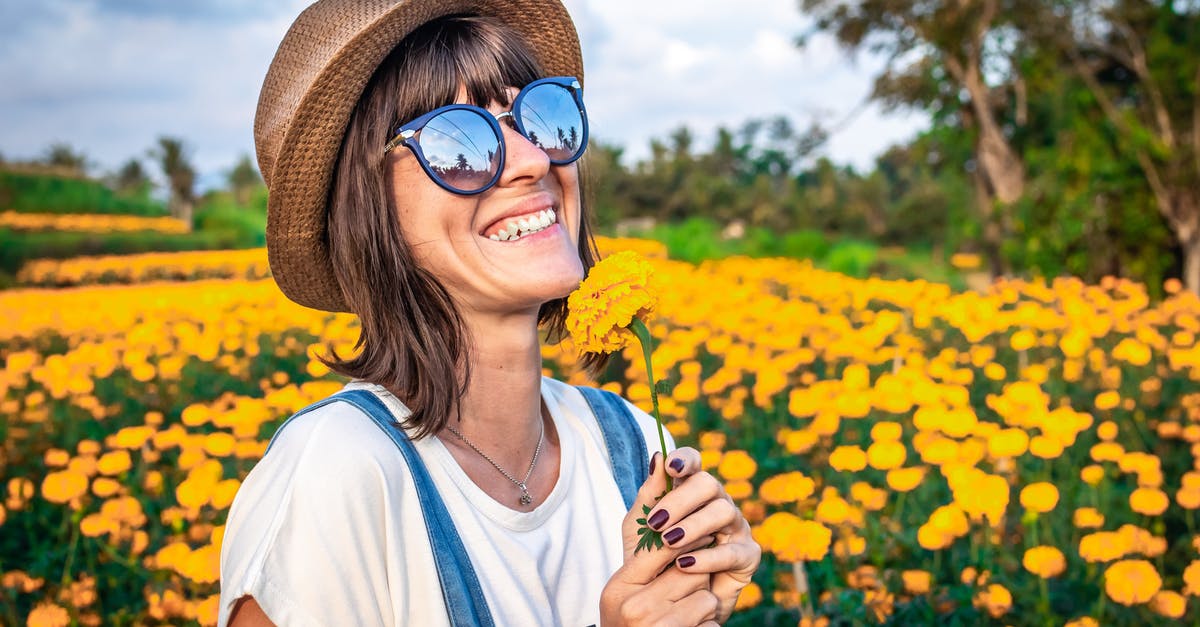 Dual passport holder travel to Bali - Woman Holding Yellow Petaled Flowers Dual passport holder travel to Bali - Woman Holding Yellow Petaled Flowers