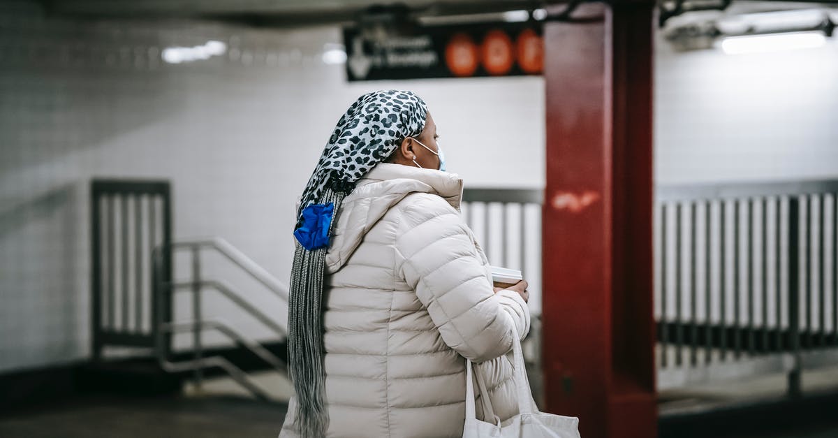 During COVID, which Schengen Zone countries can be entered through non-Schengen corridor countries, without quarantine? (April 2021) - Faceless female in sterile mask walking through underground passage with paper cup of beverage