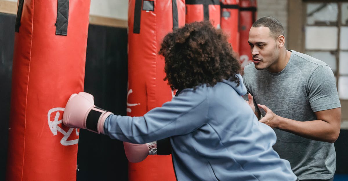 EasyJet underseat bag size - Ethnic male trainer cheering black woman hitting punching bag EasyJet underseat bag size - Ethnic male trainer cheering black woman hitting punching bag