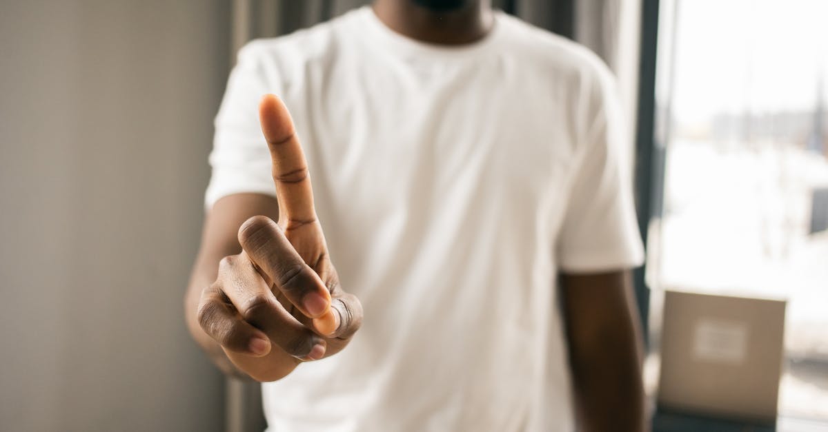 easyJet won't refund because it says 'no-show' but they denied boarding - Crop anonymous African American male in white t shirt showing stop gesture with index finger pointing up in light room on blurred background easyJet won't refund because it says 'no-show' but they denied boarding - Crop anonymous African American male in white t shirt showing stop gesture with index finger pointing up in light room on blurred background