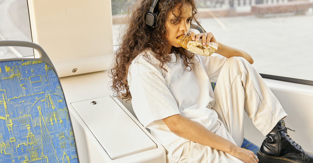 Eating alone in London - A Girl Eating Bread while Listening on Her Headphones Eating alone in London - A Girl Eating Bread while Listening on Her Headphones