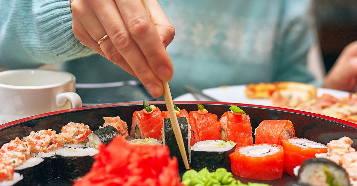 Eating fish eye in Japan - Close-up of Person Eating Sushi Eating fish eye in Japan - Close-up of Person Eating Sushi