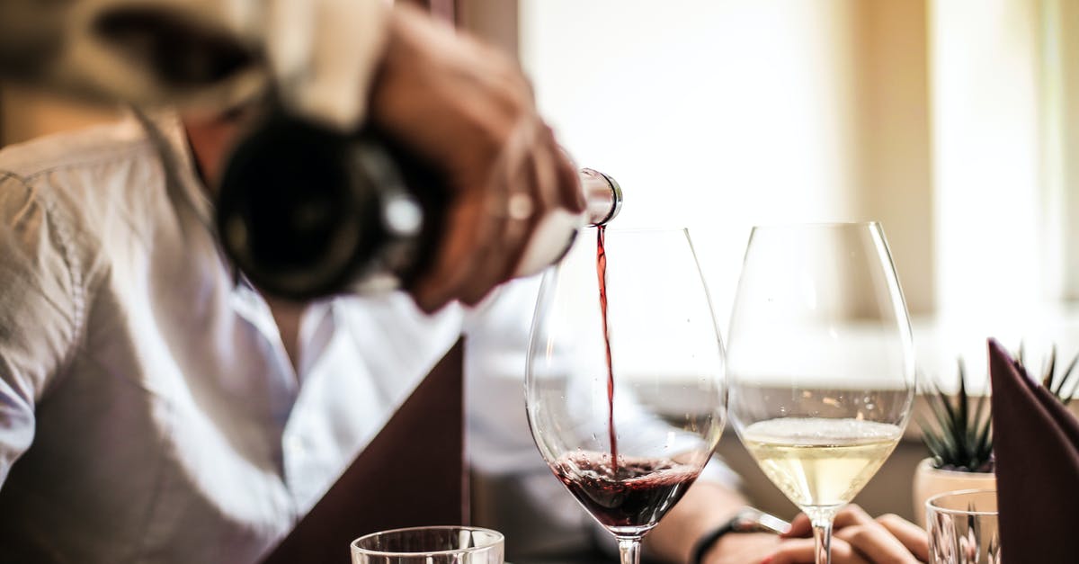 Economy ticket, but enjoy first-class service? - Crop man pouring red wine in glass in restaurant Economy ticket, but enjoy first-class service? - Crop man pouring red wine in glass in restaurant