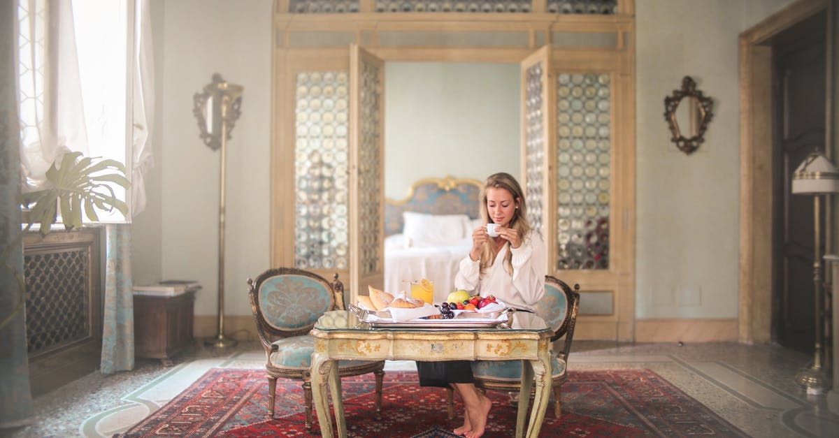 Economy ticket, but enjoy first-class service? - Woman enjoying breakfast in luxury hotel room Economy ticket, but enjoy first-class service? - Woman enjoying breakfast in luxury hotel room