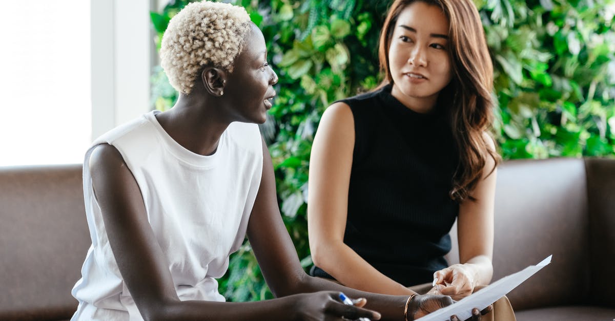 ECR status-related question - Diverse women talking about job while discussing contract and looking at each other in conference hall ECR status-related question - Diverse women talking about job while discussing contract and looking at each other in conference hall