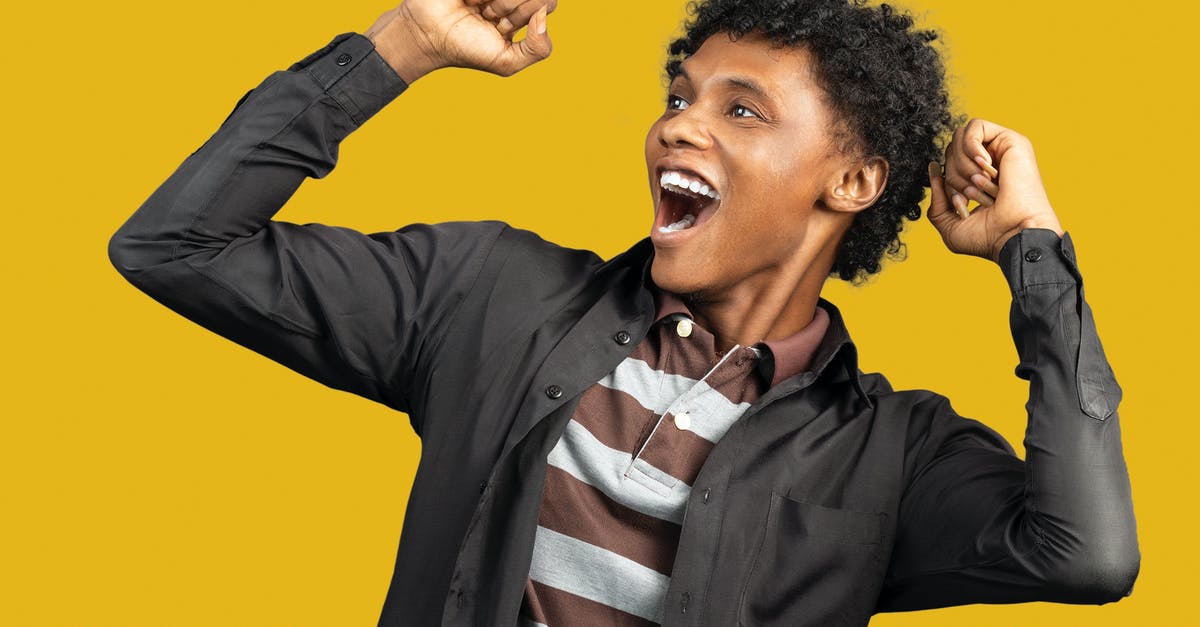 Effect of 10-year UK ban on US Visa Lottery winner - Expressive African American male wearing casual clothes standing against yellow background in studio and raising fists in triumph while looking away and screaming happily Effect of 10-year UK ban on US Visa Lottery winner - Expressive African American male wearing casual clothes standing against yellow background in studio and raising fists in triumph while looking away and screaming happily