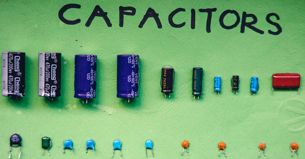 Electrical compatibility between different countries - Top view layout of various capacitors for storing electrical energy of different sizes and capacities arranged on green background with inscription Electrical compatibility between different countries - Top view layout of various capacitors for storing electrical energy of different sizes and capacities arranged on green background with inscription