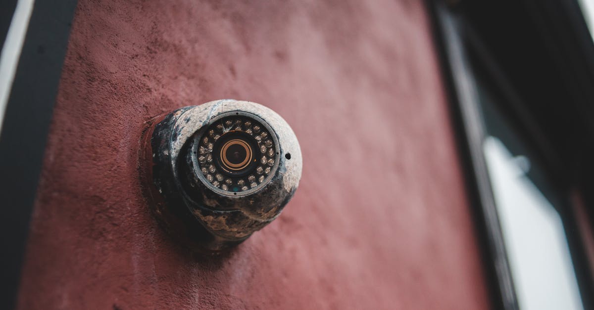 Electronic devices security on airplanes - Old security camera on shabby building wall Electronic devices security on airplanes - Old security camera on shabby building wall