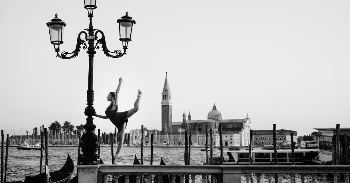 Emotive Sculpture in a Port - Where Is It? - Woman Standing on One Leg on Railing and Holding Triple Lamppost Emotive Sculpture in a Port - Where Is It? - Woman Standing on One Leg on Railing and Holding Triple Lamppost