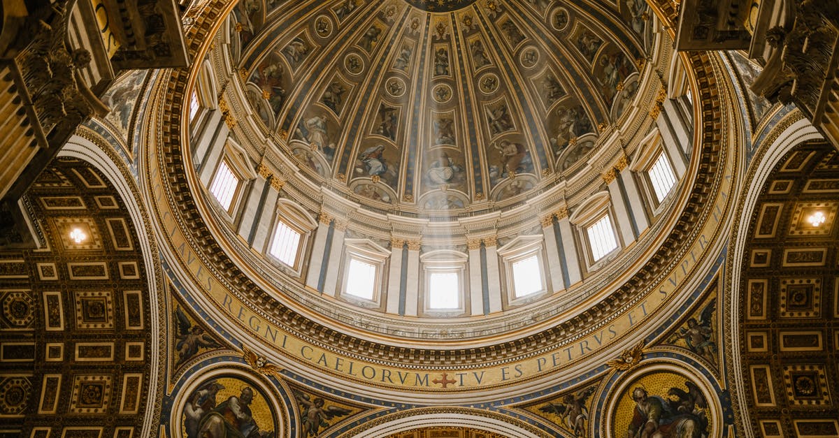 Enforcement of translational requirements for UK short term visitor visa from Italy - Low angle impressive design of dome with fresco paintings and golden ornamental elements in famous Catholic Saint Peters Basilica in Rome