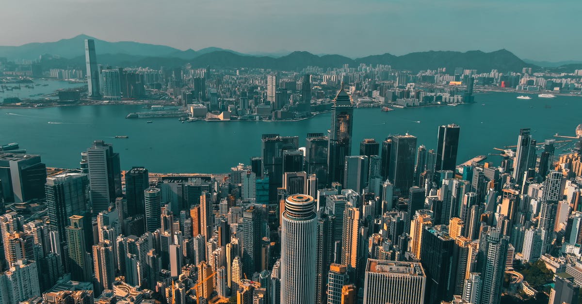 Entering China from Hong Kong without a Hong Kong visa - From above of contemporary skyscrapers of modern megapolis located on shore of river against blue sky Entering China from Hong Kong without a Hong Kong visa - From above of contemporary skyscrapers of modern megapolis located on shore of river against blue sky