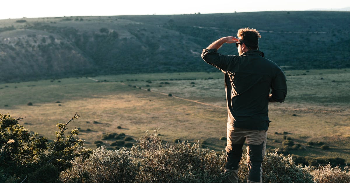 Entering the Schengen area 12 days before my visa expires - Unrecognizable traveler standing on hilltop in daytime Entering the Schengen area 12 days before my visa expires - Unrecognizable traveler standing on hilltop in daytime