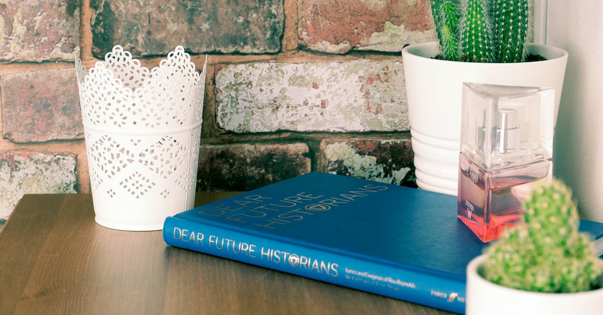 Entering the UK with a Family Permit - Blue Book on Brown Wooden Table with flower vases Entering the UK with a Family Permit - Blue Book on Brown Wooden Table with flower vases