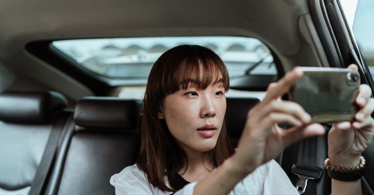 Entering UK on a Tourist Visa after refusal of citizenship application - Content woman taking photos on smartphone in car Entering UK on a Tourist Visa after refusal of citizenship application - Content woman taking photos on smartphone in car