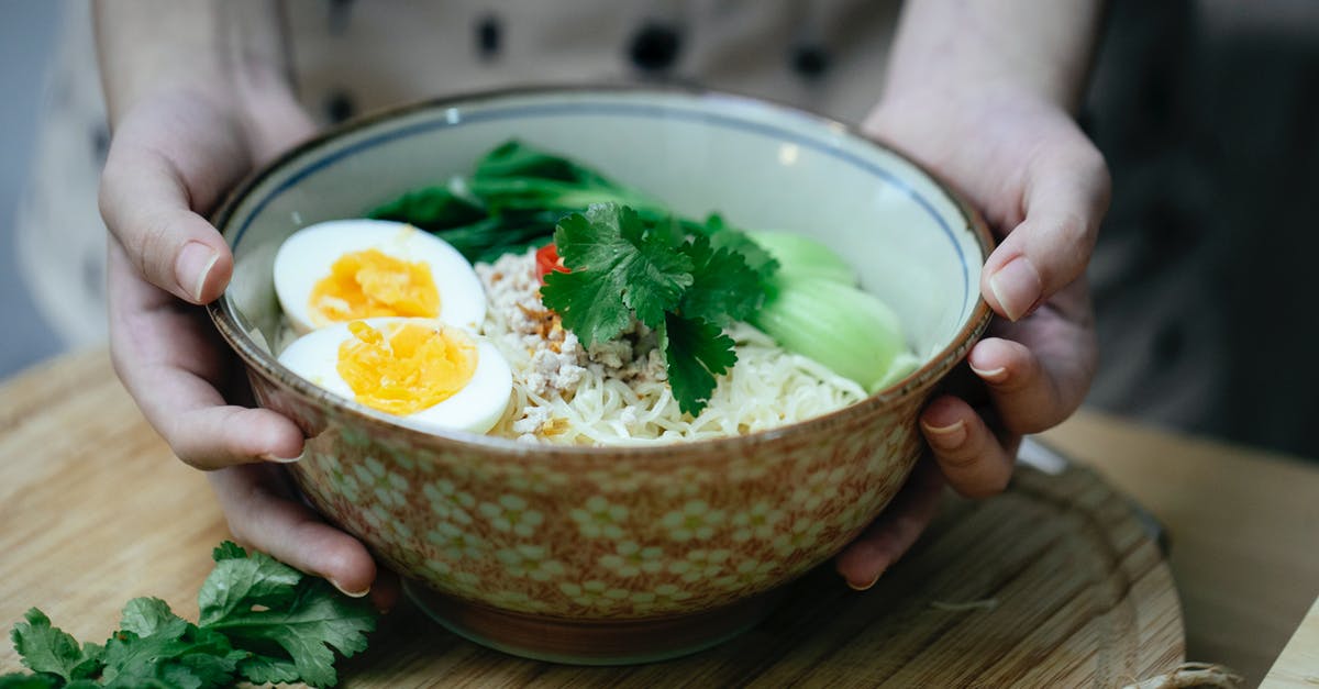 Etiquette of eating noodle soup in China - Crop unrecognizable woman touching bowl with traditional ramen soup Etiquette of eating noodle soup in China - Crop unrecognizable woman touching bowl with traditional ramen soup