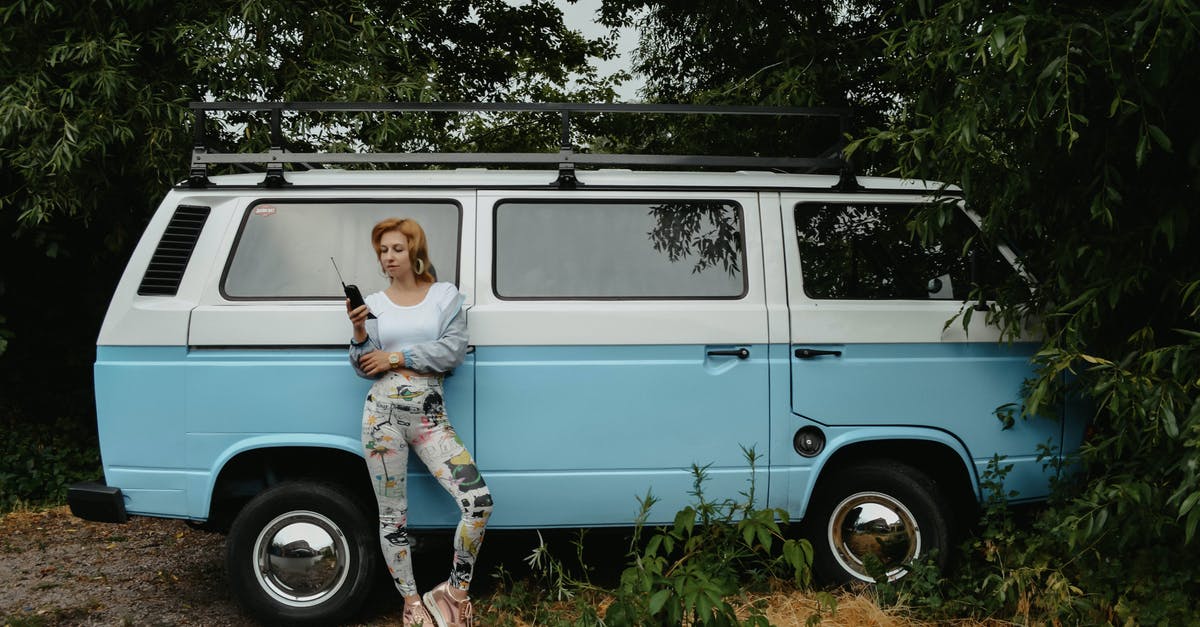 EU Roaming rules: call from abroad to foreign number - Stylish woman with wireless handset near van EU Roaming rules: call from abroad to foreign number - Stylish woman with wireless handset near van