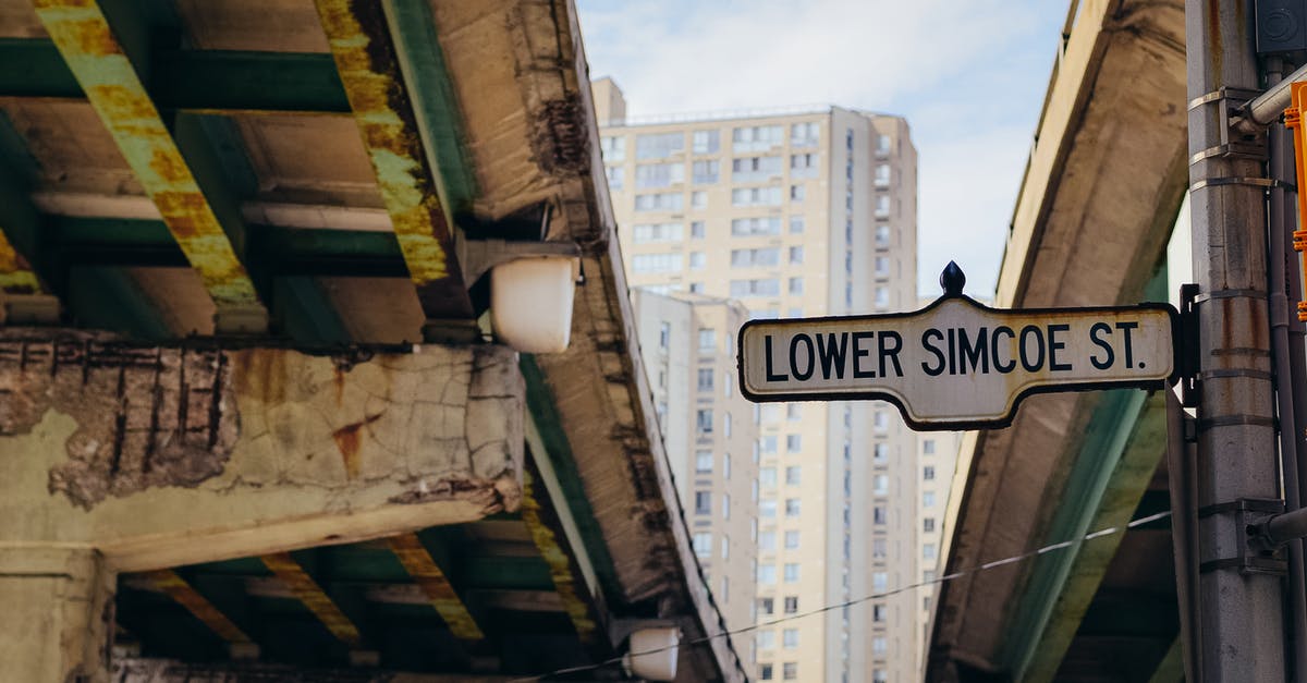Europe: differences between colours of highway road-signs - Street sign placed on pole between old overpasses Europe: differences between colours of highway road-signs - Street sign placed on pole between old overpasses