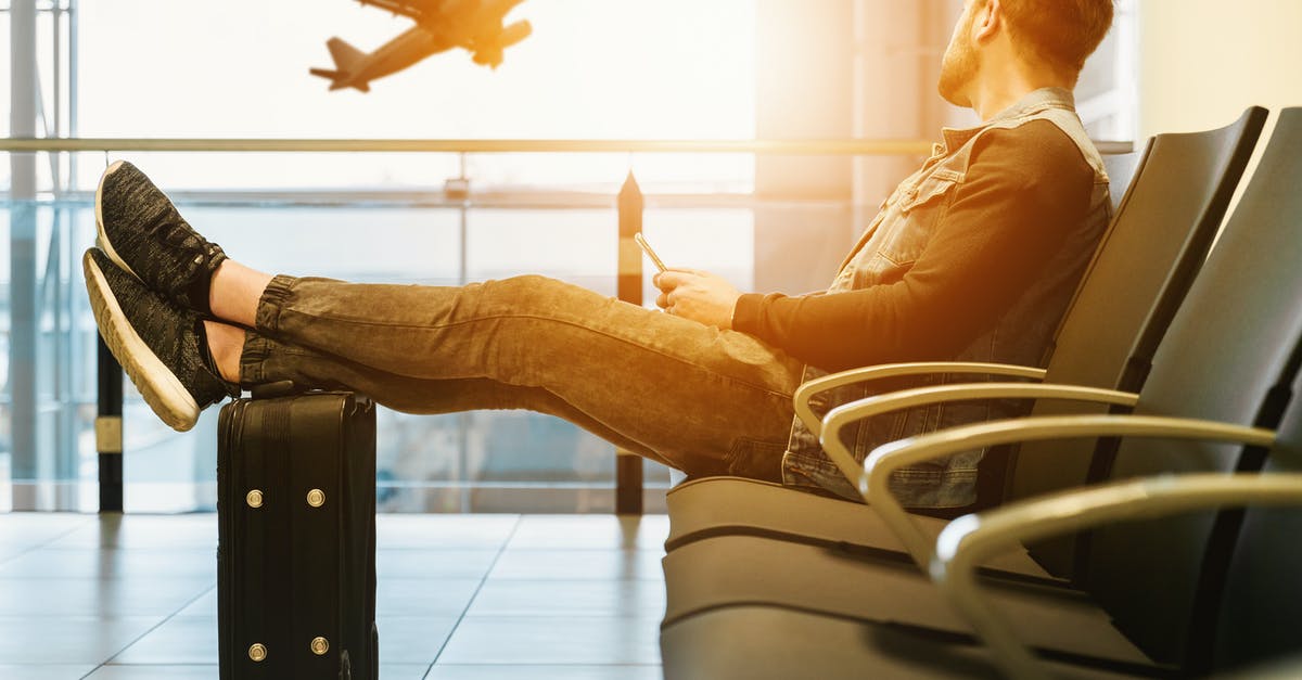 European passenger rights. Reimbursement in case of time change by airline - Man in airport waiting for boarding on plane European passenger rights. Reimbursement in case of time change by airline - Man in airport waiting for boarding on plane