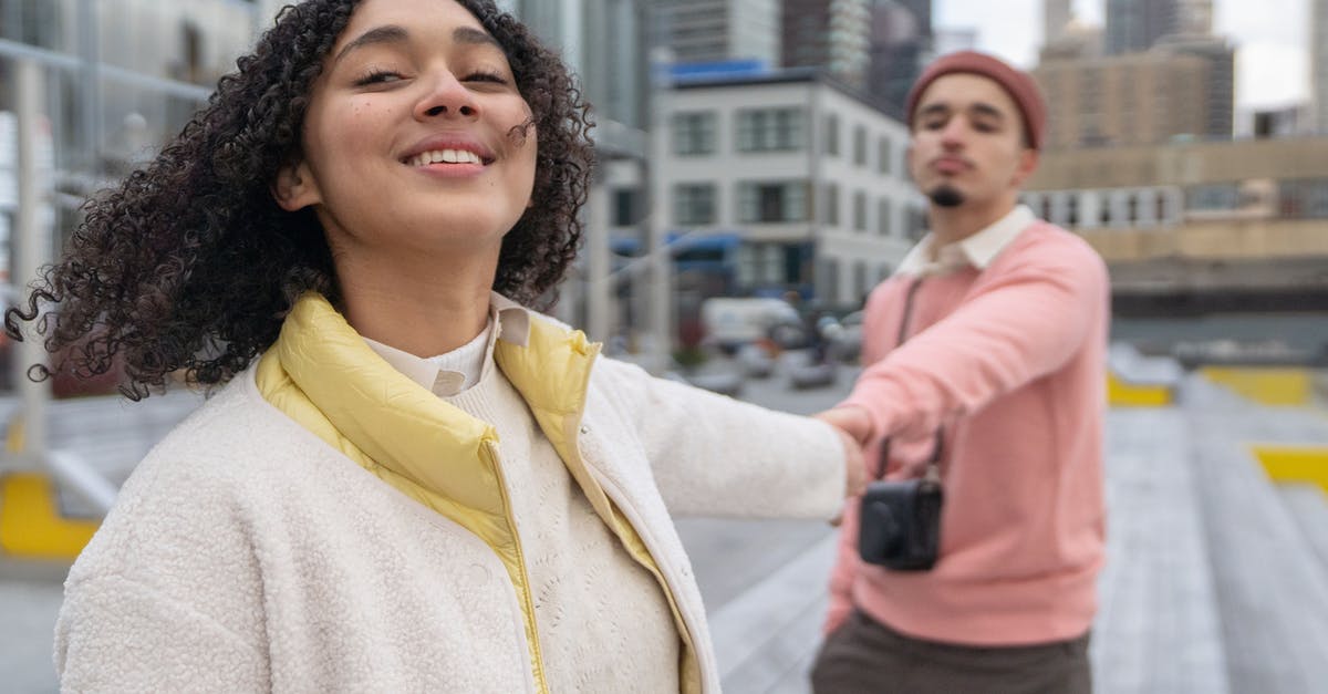 Expiration of a Delta ecredit following a changed date - Cheerful Hispanic couple with photo camera holding hands
