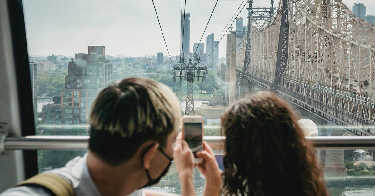 Extend tourist visa stay in USA due to coronavirus and waive I-539 fee - Unrecognizable couple riding ropeway cabin and taking photos of city Extend tourist visa stay in USA due to coronavirus and waive I-539 fee - Unrecognizable couple riding ropeway cabin and taking photos of city