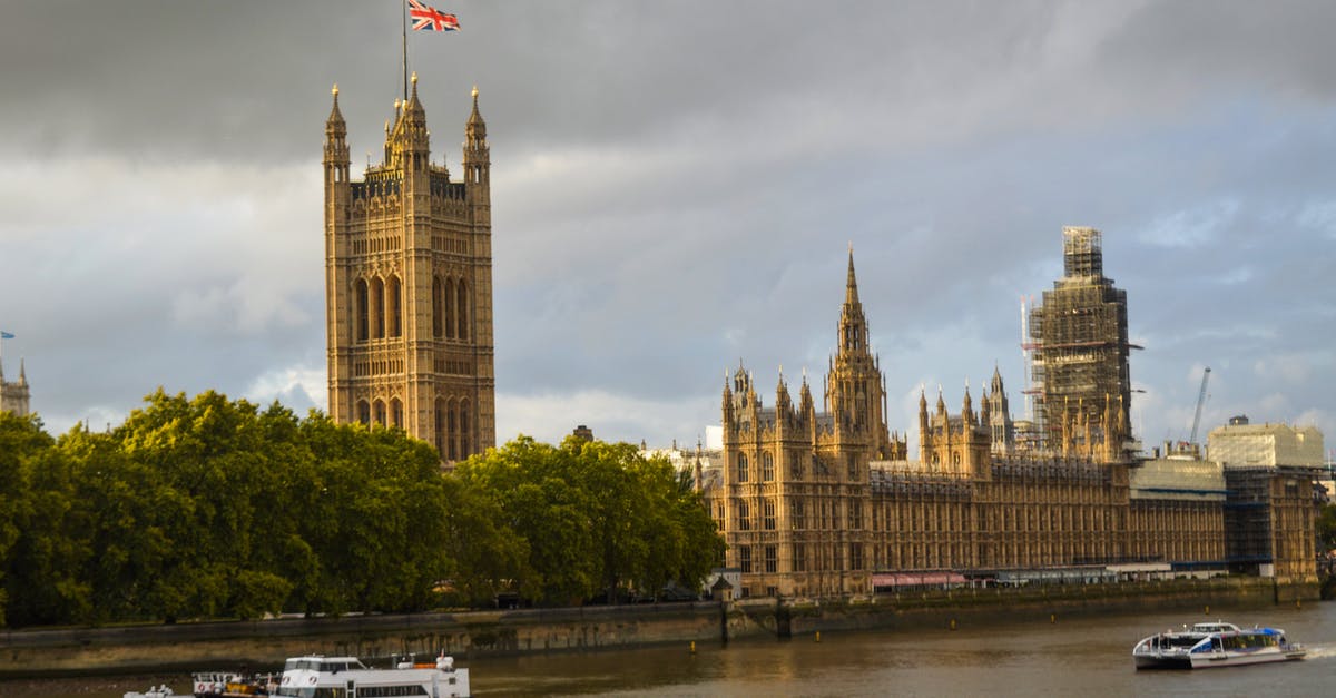 Extending 7 day London Oyster card for extra zones - The Westminster Palace on green embankment of the River Thames Extending 7 day London Oyster card for extra zones - The Westminster Palace on green embankment of the River Thames