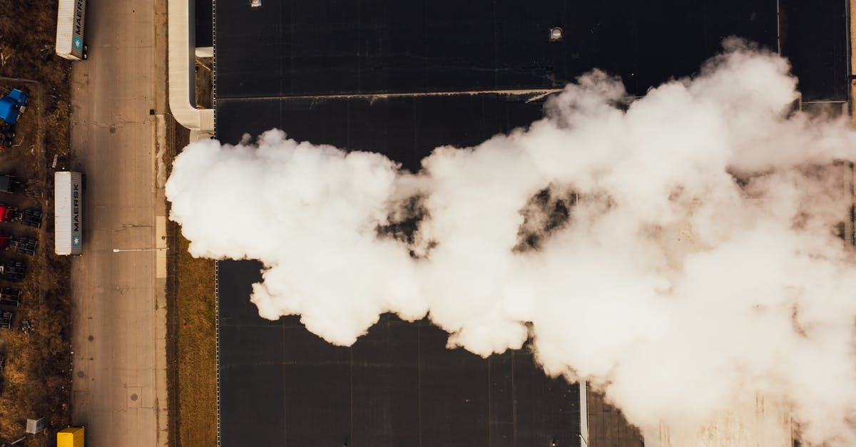 Facilities available during layovers by Air India - From above of black roof of industrial factory building with smoke pipe in daylight Facilities available during layovers by Air India - From above of black roof of industrial factory building with smoke pipe in daylight