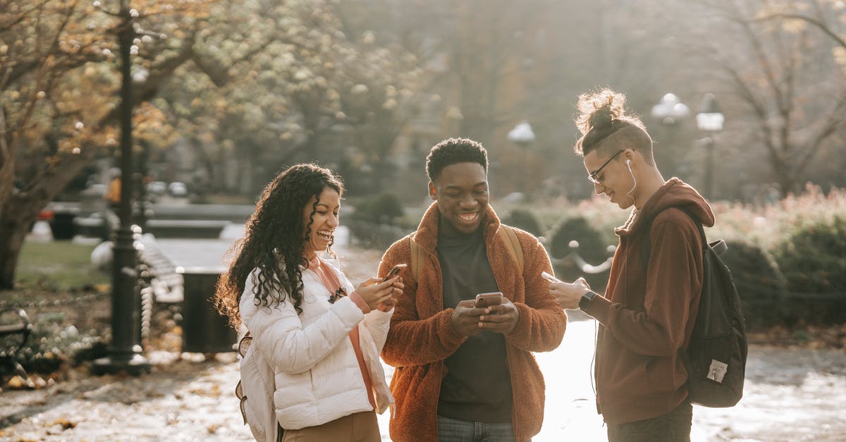 Fall asleep in terminal and miss connection fight: recover change fee - Multiracial positive male and female students using smartphones in city park Fall asleep in terminal and miss connection fight: recover change fee - Multiracial positive male and female students using smartphones in city park