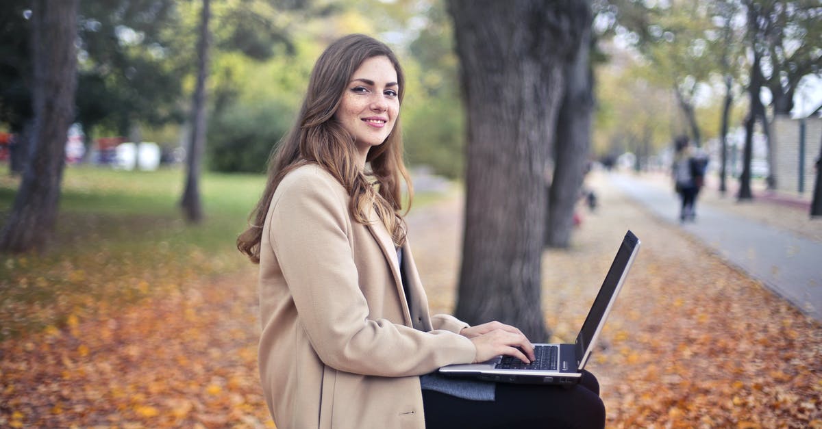Fall asleep in terminal and miss connection fight: recover change fee - Joyful confident woman using netbook in park Fall asleep in terminal and miss connection fight: recover change fee - Joyful confident woman using netbook in park