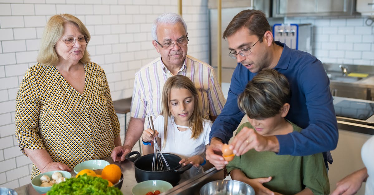 Family member of an EEA citizen - A Man in Blue Long Sleeves Teaching His Son while Holding an Egg Family member of an EEA citizen - A Man in Blue Long Sleeves Teaching His Son while Holding an Egg