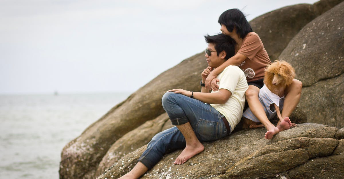 Family travel in Thailand - is it safe, can we improvise? - Couple Sitting on Boulder with Their Pet Dog Family travel in Thailand - is it safe, can we improvise? - Couple Sitting on Boulder with Their Pet Dog
