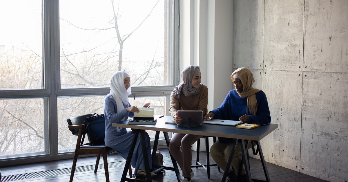 Filipino national getting a visa via a British partner - Diverse Muslim businesswomen talking about job at table with tablet Filipino national getting a visa via a British partner - Diverse Muslim businesswomen talking about job at table with tablet