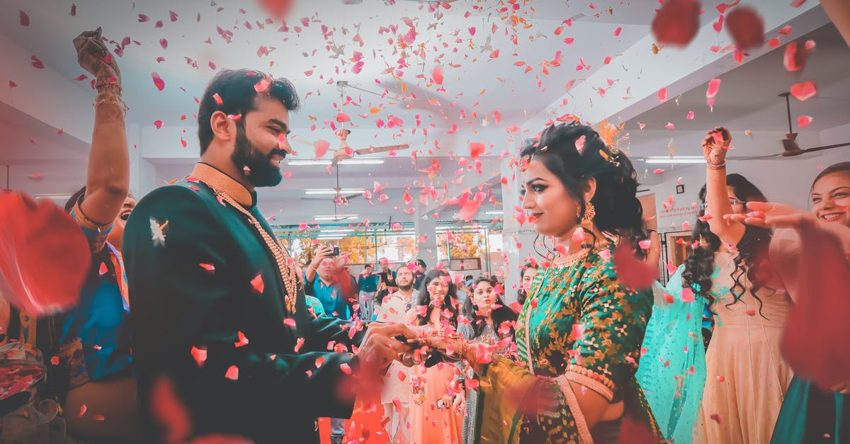 Filipino national getting a visa via a British partner - Indian people in bright festive clothes smiling and congratulating newlywed ethnic couple in falling red petals Filipino national getting a visa via a British partner - Indian people in bright festive clothes smiling and congratulating newlywed ethnic couple in falling red petals
