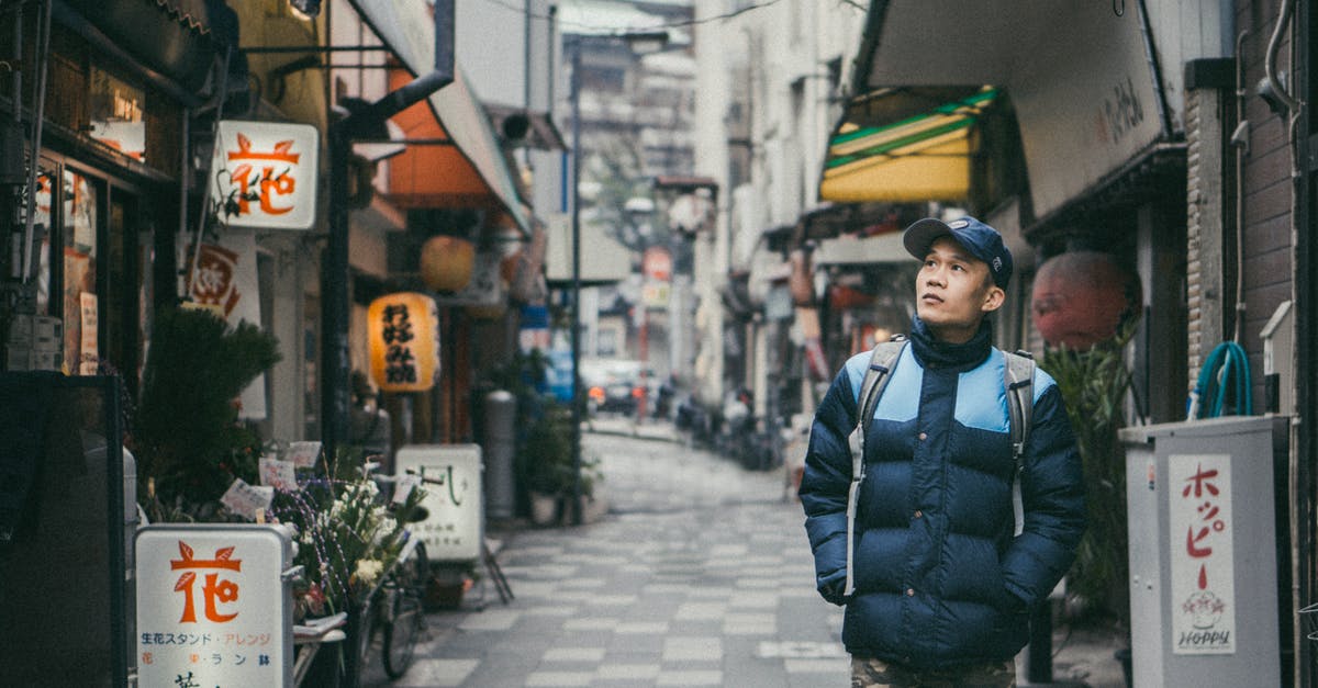 Finding non-smoking restaurants in Japan - Man Walking on Grey Concrete Alley Surrounded by Buildings Finding non-smoking restaurants in Japan - Man Walking on Grey Concrete Alley Surrounded by Buildings