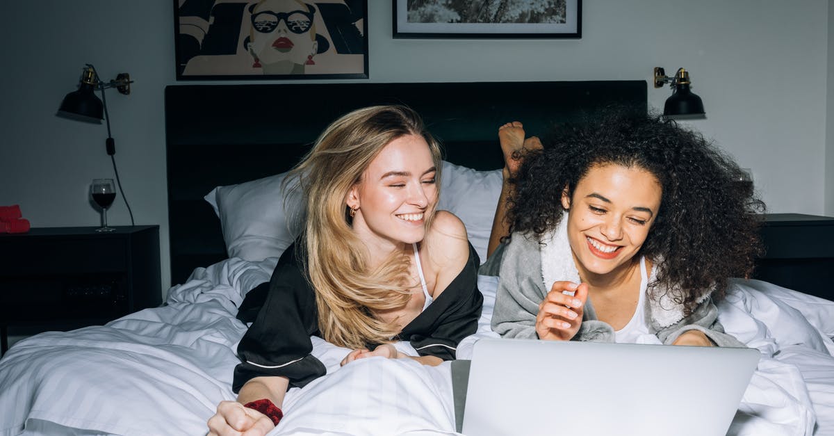 Finding sleepover spots in internet cafes in Japan? - Two Young Women Having Fun While Looking at a Laptop