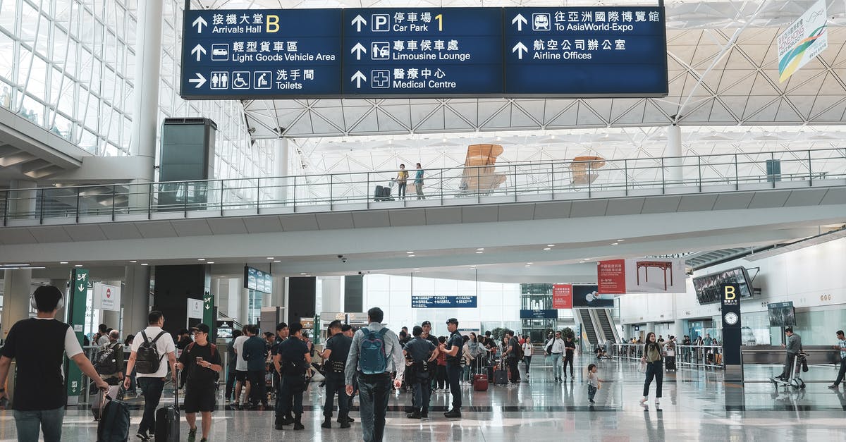 Finding the "Airport Express Shuttle Bus" at Hong Kong station? - People Walking on a Building Finding the "Airport Express Shuttle Bus" at Hong Kong station? - People Walking on a Building