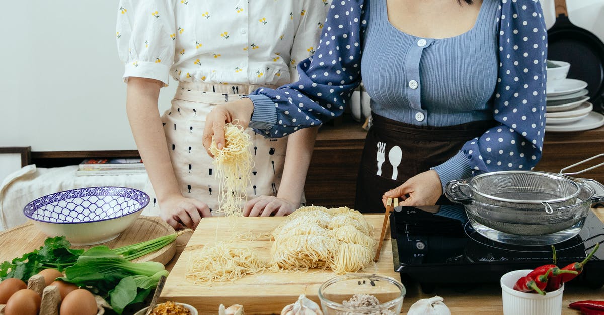 First-time Chinese visa applicant needing to apply at a Chinese consulate in Canada - Crop anonymous ladies in aprons standing near wooden table with various ingredients and utensil while preparing to cook homemade pasta together First-time Chinese visa applicant needing to apply at a Chinese consulate in Canada - Crop anonymous ladies in aprons standing near wooden table with various ingredients and utensil while preparing to cook homemade pasta together
