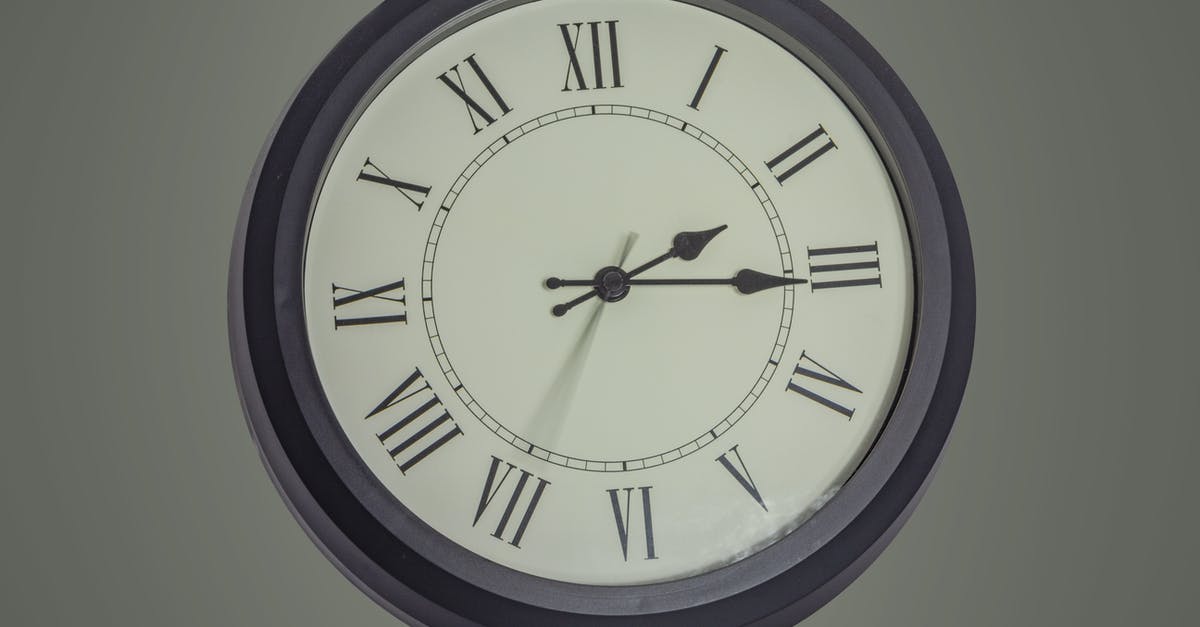 Flight compensation due to a delay in the second leg only - Round black mechanical clock with Roman numerals hanging on gray wall Flight compensation due to a delay in the second leg only - Round black mechanical clock with Roman numerals hanging on gray wall