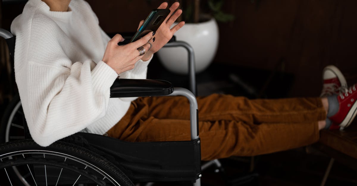 Flying for the first time tomorrow, is a physical boarding pass required or is the app enough? - Side view of crop unrecognizable female millennial with disability sitting in wheelchair and browsing mobile phone Flying for the first time tomorrow, is a physical boarding pass required or is the app enough? - Side view of crop unrecognizable female millennial with disability sitting in wheelchair and browsing mobile phone