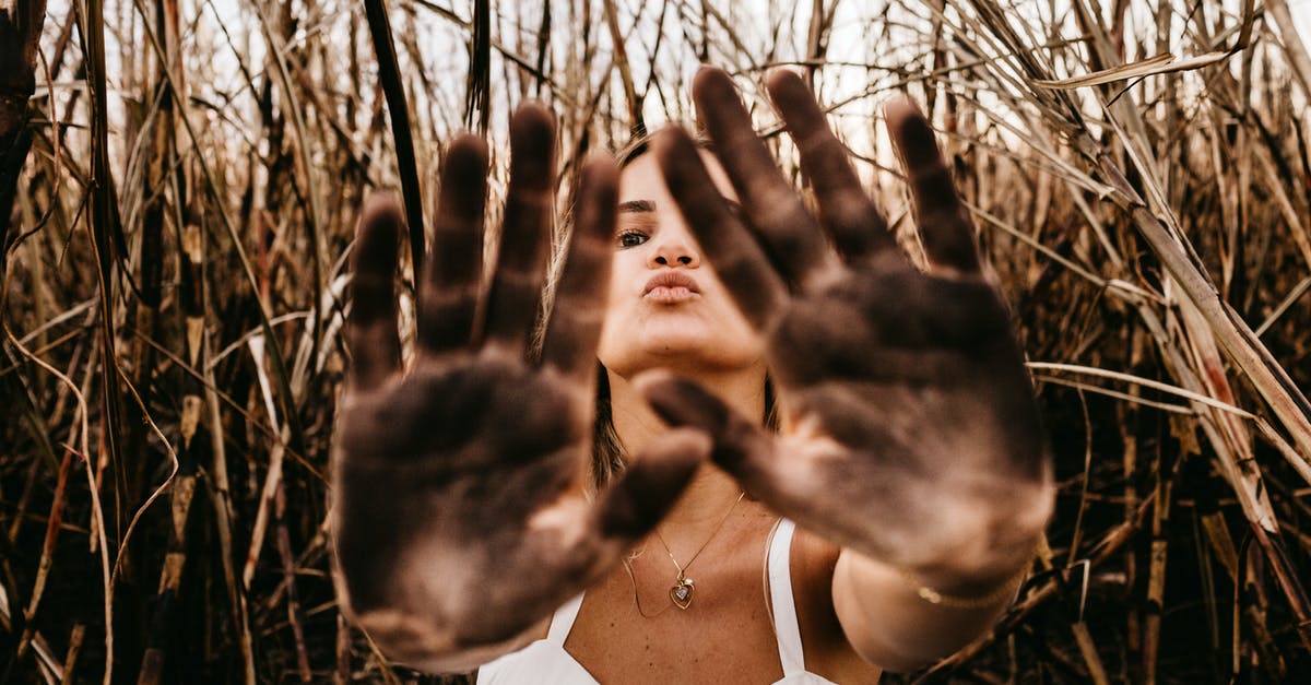 Flying from San Francisco to Palm Springs via Phoenix. Will I have to re-claim and re-check bags at Phoenix? - Woman giving five with dirty palms of hands in field