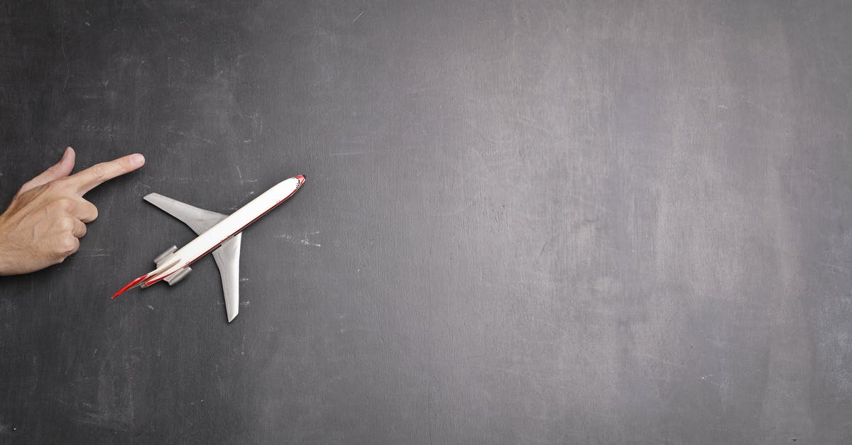 Flying from Toronto to Mumbai via Newark - Toy plane and human hand on chalkboard Flying from Toronto to Mumbai via Newark - Toy plane and human hand on chalkboard