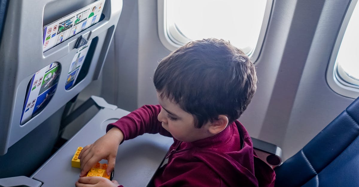 Flying with a lap child on a code shared flight - Boy playing with toy on plane Flying with a lap child on a code shared flight - Boy playing with toy on plane